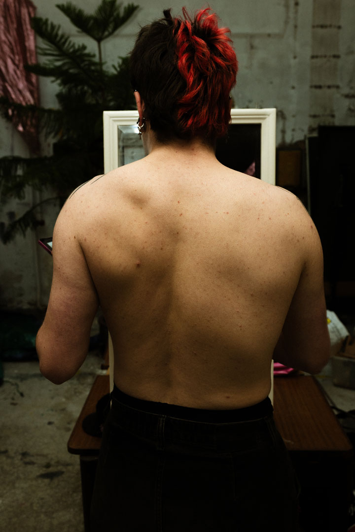 Queer performer van achteren gefotografeerd, Maastricht Nederland 2026 — Luca van Ruiten